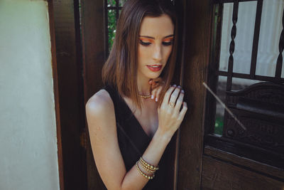 Young woman looking through window