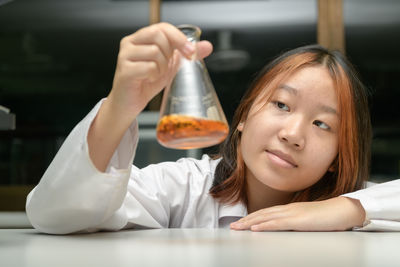 Education concept. little scientists children is looking at erlenmeyer flask containing chemicals 