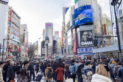 People walking on street amidst buildings in city