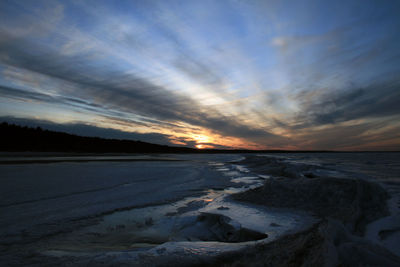 Scenic view of sea against dramatic sky during sunset