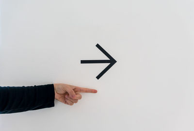 Close-up of hand holding paper over white background