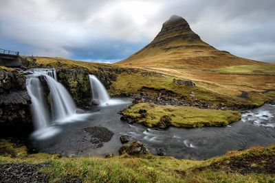 Scenic view of waterfall against sky