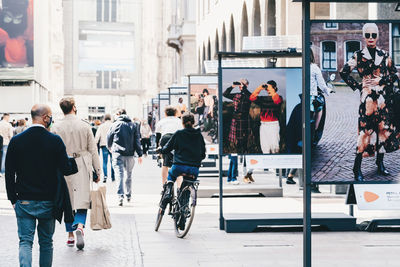 Rear view of people walking on city street