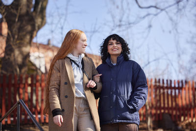 Smiling female friends walking in park