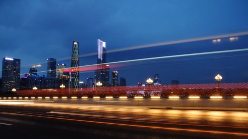 Illuminated light trails on road against sky at night