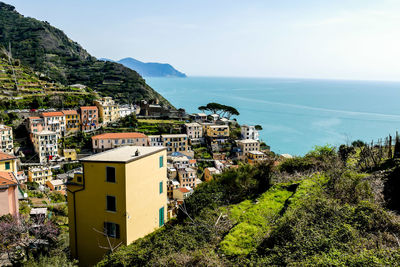 High angle view of townscape by sea against sky