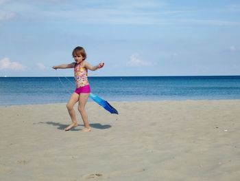 Full length of girl on beach against sky