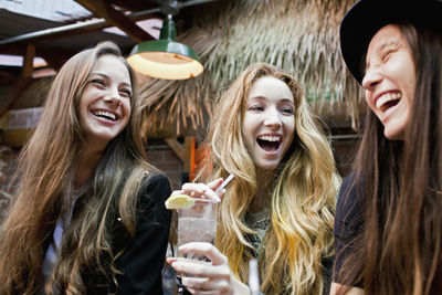 Happy young friends enjoying drinks at a bar