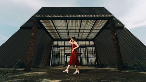 Woman walking by built structure in city