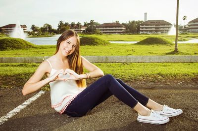 Rear view of woman sitting on lawn