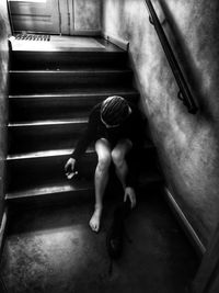High angle view of man sitting on staircase at home