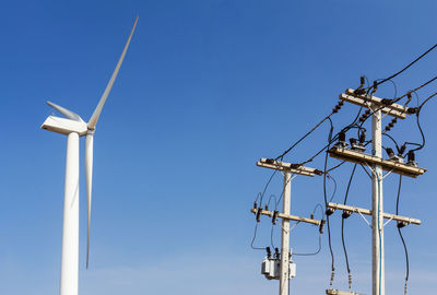 Wind energy turbine power station and power lines transporting electricity.