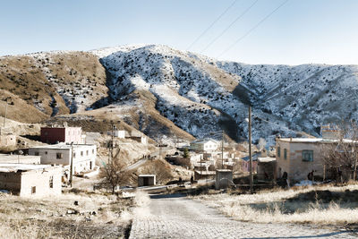 Houses in town against clear sky during winter