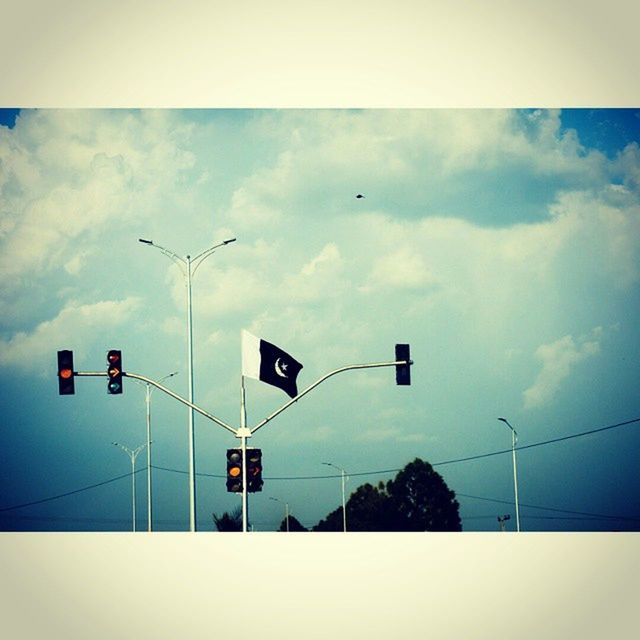 low angle view, sky, street light, guidance, road sign, cloud - sky, communication, transfer print, lighting equipment, pole, power line, transportation, arrow symbol, cloud, directional sign, auto post production filter, cloudy, information sign, no people, day