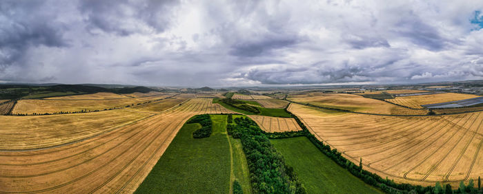 Panoramic view of agricultural field against sky