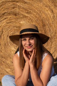 Portrait of young woman wearing hat at field