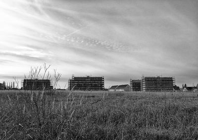 Buildings on field against sky