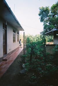 Man outside house against sky