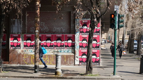 People walking on footpath by street in city