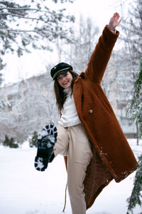 Portrait of young woman standing on snow covered field