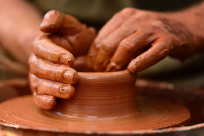 Cropped hand making pottery at workshop