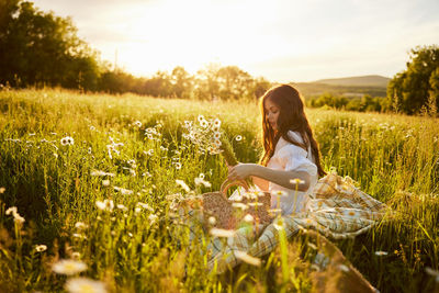 Rear view of woman standing on grassy field