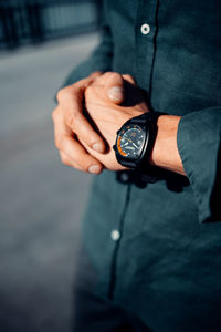 Midsection of man holding clock