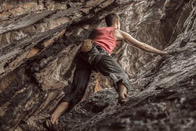 Low angle view of man climbing on mountain