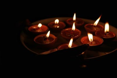 Close-up of lit diyas/ oil lamps during diwali in the dark