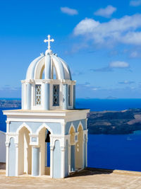 Exterior of building by sea against blue sky