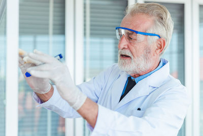 Midsection of man holding eyeglasses