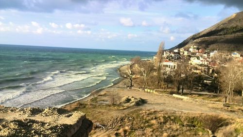 Scenic view of sea by buildings against sky