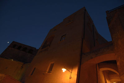 Low angle view of illuminated building against clear sky at night