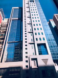 Low angle view of modern buildings against blue sky