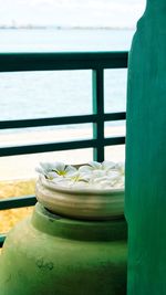 Close-up of water bottle on railing