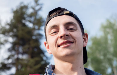 Close up of happy young man looking at camera on a sunny day