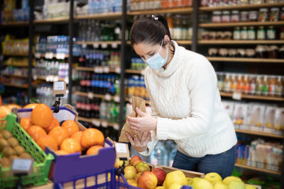 Midsection of woman holding ice cream at store