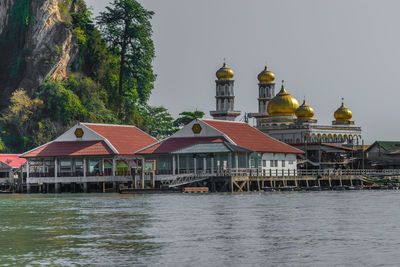 View of building by river against sky