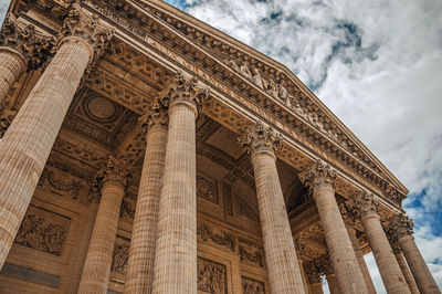 Columns at the pantheon entrance in neoclassical style and cloudy sky in paris. france.