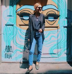 Full length of young man standing against wall
