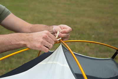 Aluminum mounting arcs for the installation of a tourist yellow tent in the hand close-up.