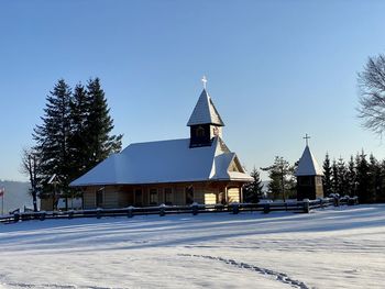 Built structure by building against clear sky during winter