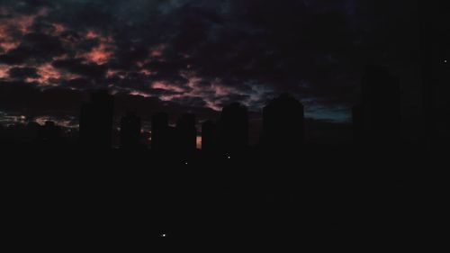 View of cityscape against cloudy sky during sunset