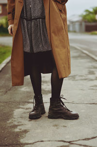 Low section of woman standing on footpath