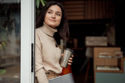 Portrait of young woman using mobile phone at home