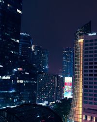 Illuminated buildings in city against sky at night