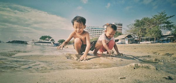 Full length of children on beach against sky