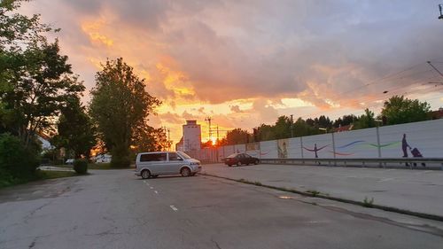 Cars on road against sky during sunset