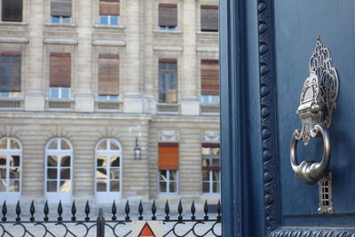 A big blue door with antique silver knocker with some rust, bordeaux, france. selective focusing.