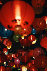 Low angle view of illuminated lanterns hanging at night